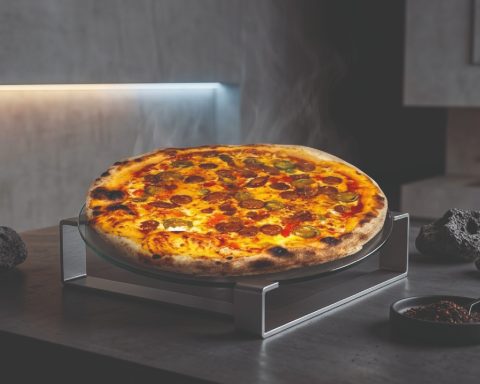 Pizza relevée avec piments jalapeños, merguez et poivrons, dans un décor épuré moderne